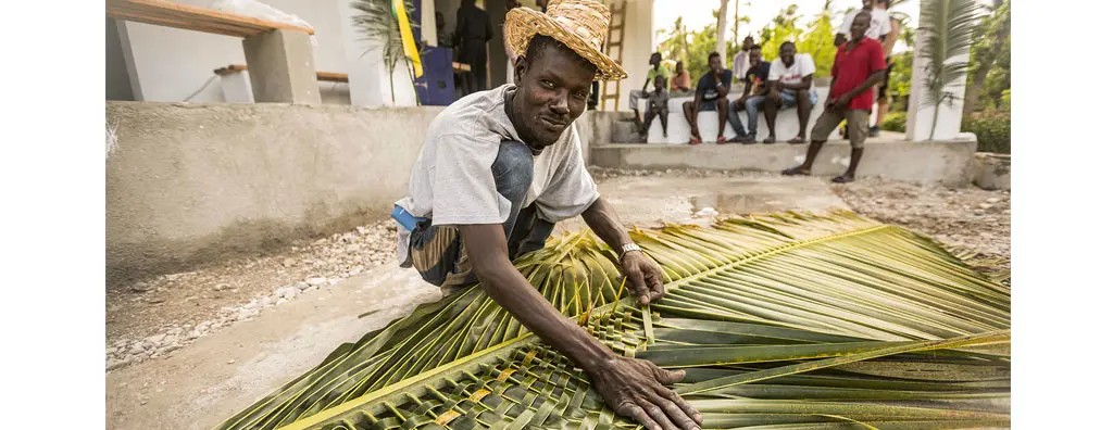 Man weaving palm leaves into a mat