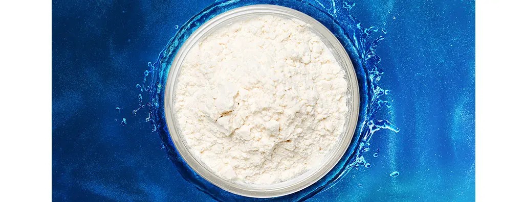 A circular glass jar filled with white powder representing Evernityl is centred against a vibrant blue background, resembling rippling water.